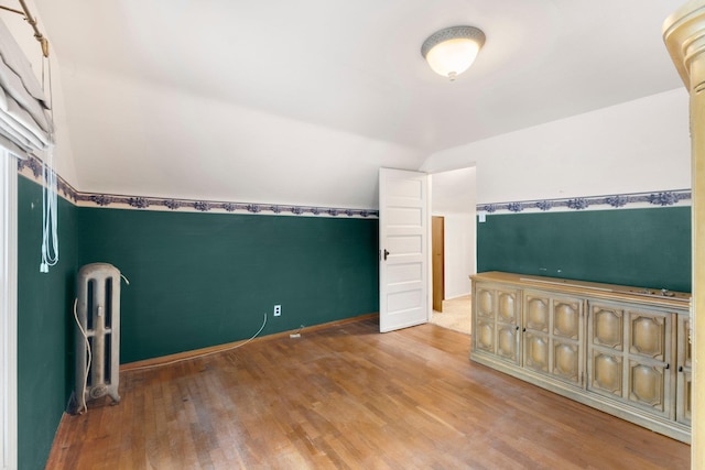 bonus room featuring radiator heating unit, hardwood / wood-style floors, and lofted ceiling