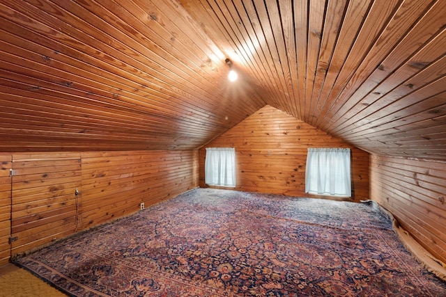 additional living space featuring lofted ceiling, wooden ceiling, and wood walls