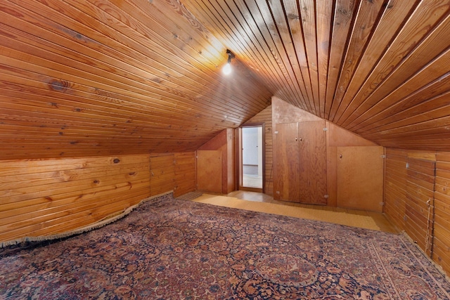 additional living space featuring wood walls, wood ceiling, and lofted ceiling