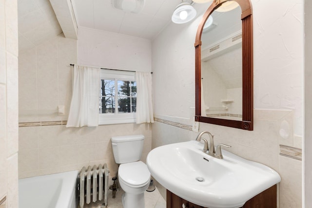 bathroom with radiator, sink, tile walls, toilet, and a tub