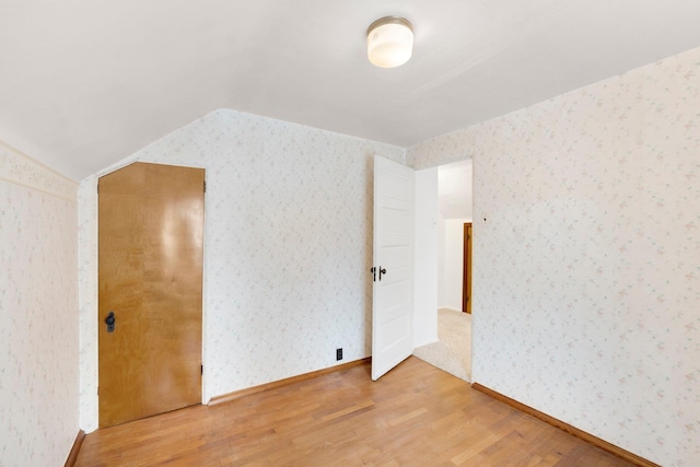 interior space with hardwood / wood-style floors and vaulted ceiling