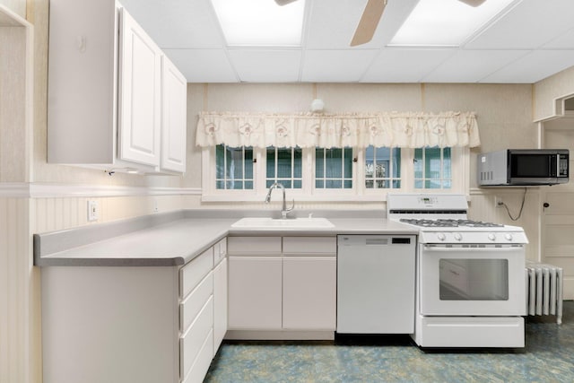 kitchen featuring white cabinetry, sink, a drop ceiling, and white appliances