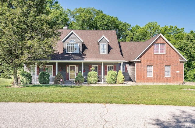 cape cod house with covered porch and a front yard