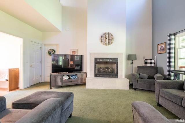 living room featuring a fireplace, a towering ceiling, and carpet floors