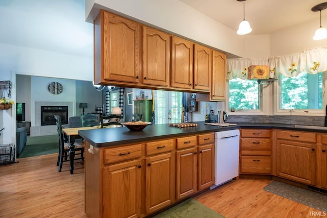 kitchen featuring dishwasher, light hardwood / wood-style flooring, hanging light fixtures, and a fireplace