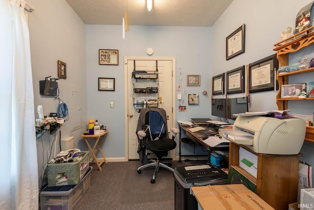 carpeted home office with a textured ceiling