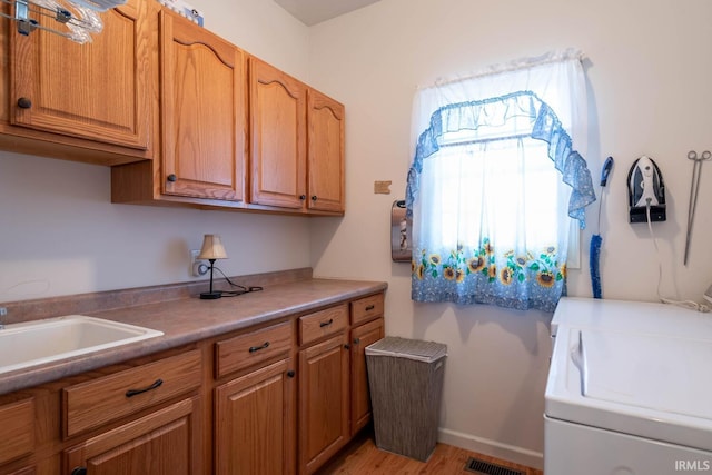 laundry area with washer and dryer, cabinets, and sink