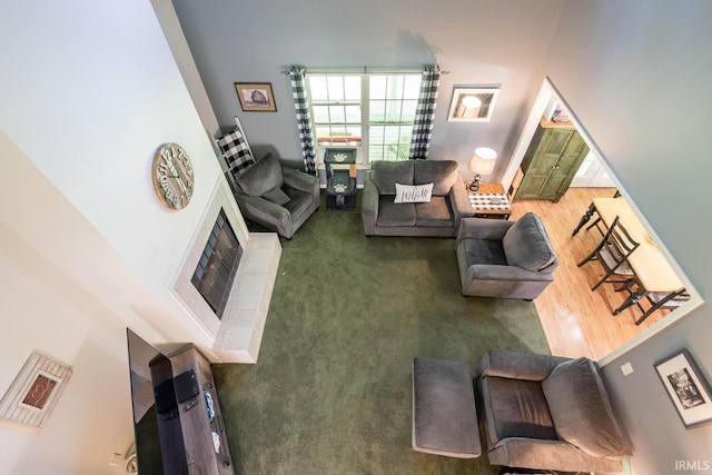 carpeted living room featuring a tiled fireplace