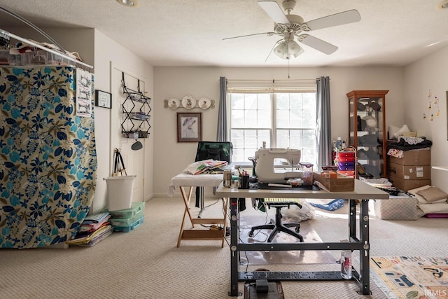 home office with carpet flooring, ceiling fan, and a textured ceiling