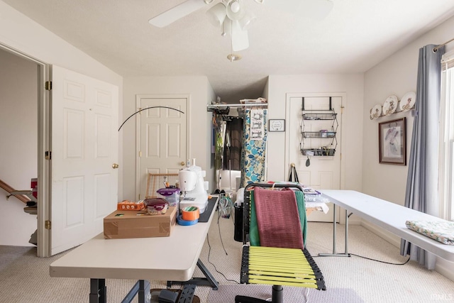 carpeted office space with ceiling fan