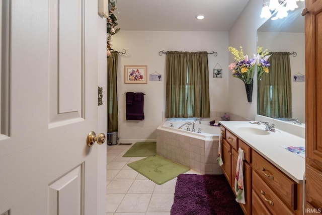 bathroom with tile patterned floors, vanity, and a relaxing tiled tub