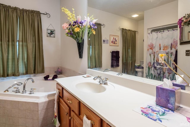 bathroom with tiled bath and vanity