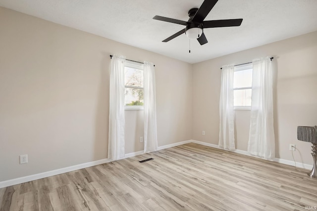 unfurnished room with light wood-type flooring, a wealth of natural light, and ceiling fan