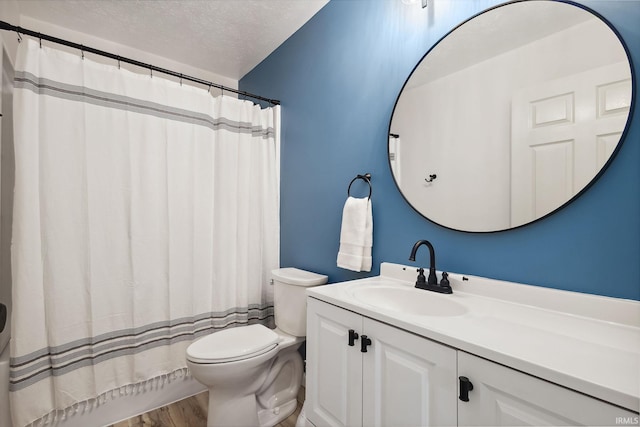 bathroom featuring vanity, hardwood / wood-style flooring, a shower with shower curtain, toilet, and a textured ceiling