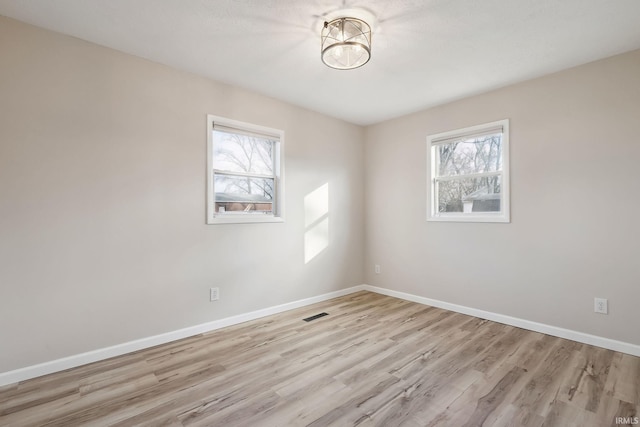 unfurnished room featuring light wood-type flooring and a wealth of natural light