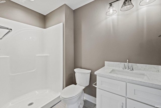 bathroom with vanity, toilet, and a shower