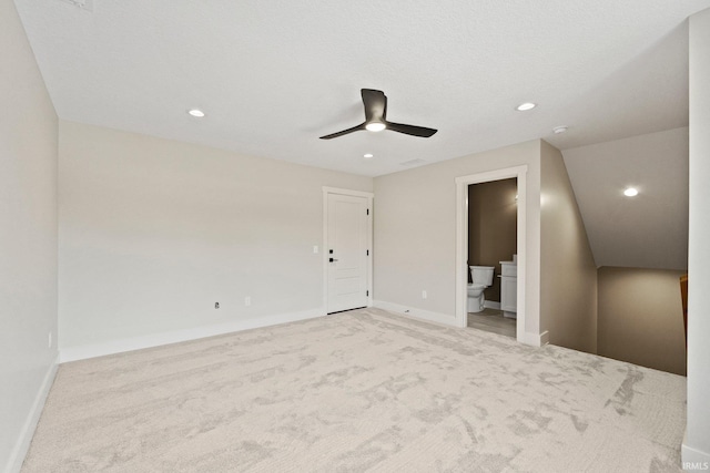 unfurnished bedroom with ensuite bath, ceiling fan, and light carpet