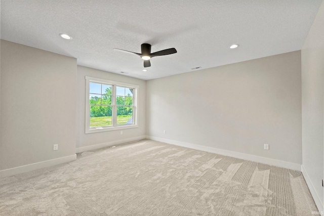 carpeted spare room with ceiling fan and a textured ceiling