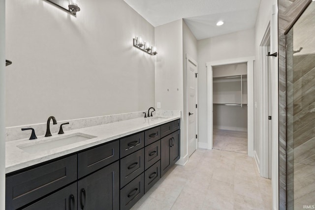 bathroom featuring a textured ceiling, vanity, and walk in shower