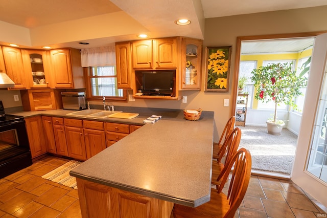 kitchen featuring light tile patterned flooring, sink, a wealth of natural light, and black / electric stove