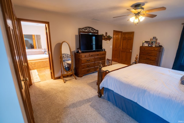 bedroom featuring connected bathroom, ceiling fan, and light carpet