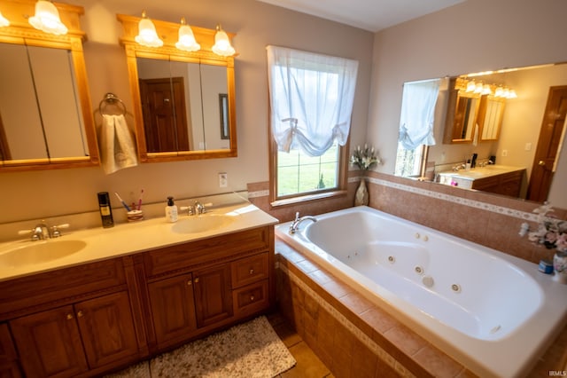 bathroom with tile patterned floors, vanity, and a relaxing tiled tub