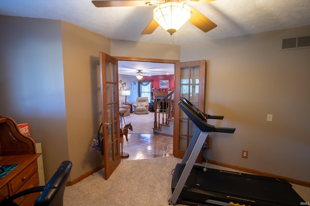 workout area featuring a textured ceiling, light carpet, and french doors