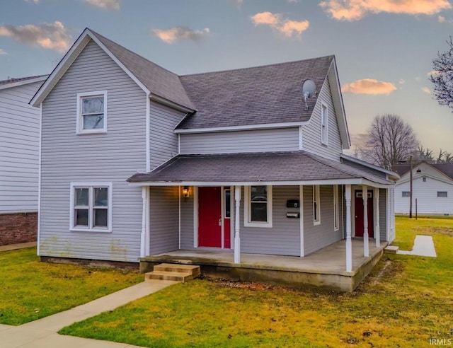 farmhouse inspired home with a lawn and a porch