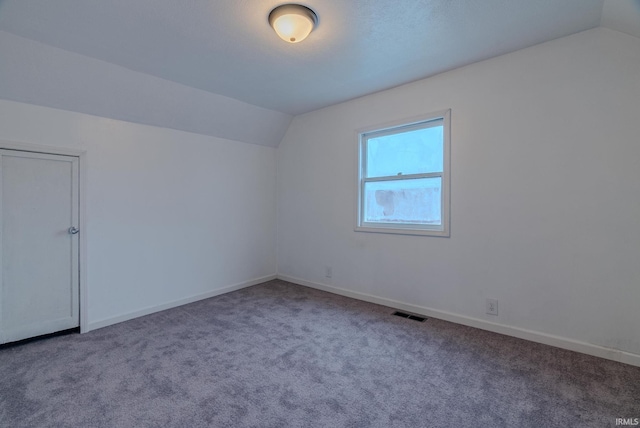 bonus room with carpet floors and vaulted ceiling