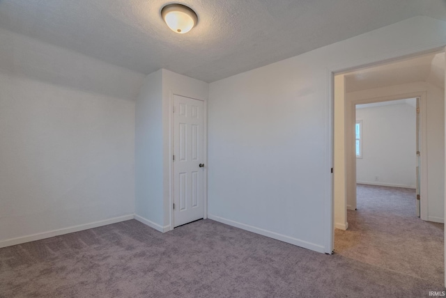 interior space with a textured ceiling and light carpet