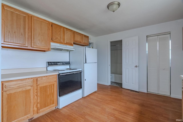 kitchen featuring white appliances and light hardwood / wood-style flooring