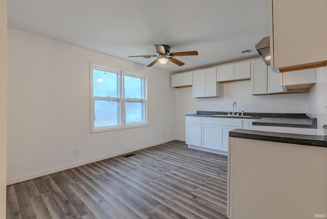 kitchen featuring light hardwood / wood-style flooring, white cabinetry, ceiling fan, and sink