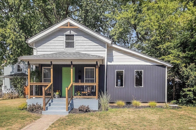 bungalow featuring covered porch and a front yard