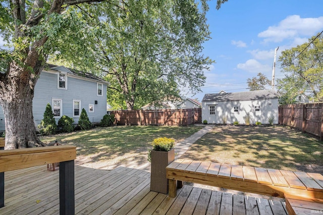 wooden terrace featuring a lawn and an outdoor structure