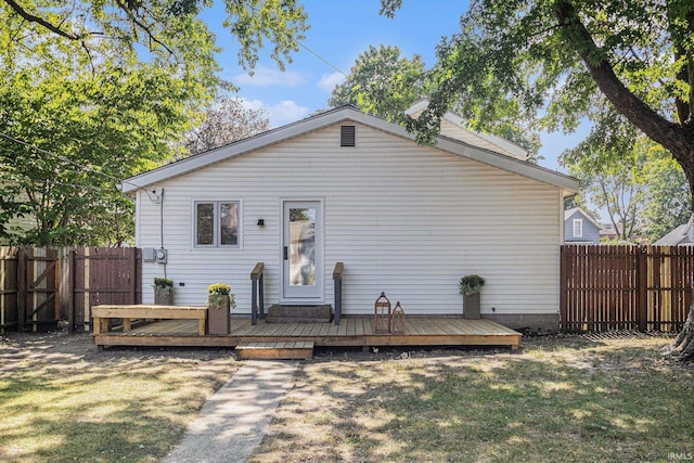 view of front facade featuring a front lawn and a wooden deck