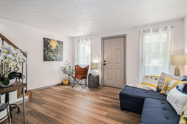 living room with a textured ceiling, hardwood / wood-style flooring, and a wealth of natural light