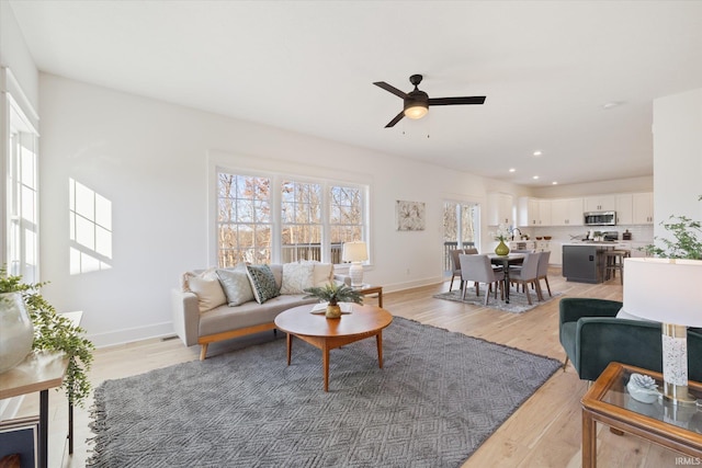 living room featuring light hardwood / wood-style floors and ceiling fan