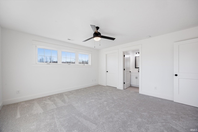 unfurnished bedroom with light carpet, ensuite bathroom, and ceiling fan