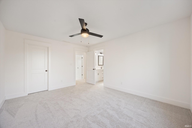 unfurnished bedroom with ceiling fan, light colored carpet, and ensuite bathroom