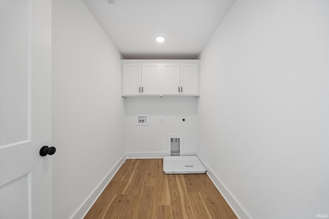 clothes washing area featuring electric dryer hookup, cabinets, gas dryer hookup, hookup for a washing machine, and light hardwood / wood-style flooring