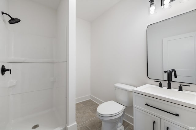 bathroom with vanity, toilet, and a shower