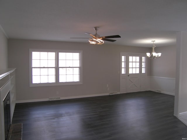 unfurnished living room featuring ceiling fan with notable chandelier, a fireplace, and dark wood-type flooring