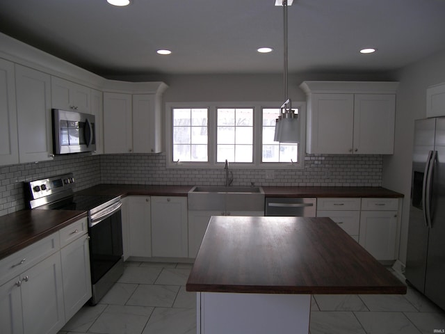 kitchen featuring backsplash, wood counters, sink, and stainless steel appliances