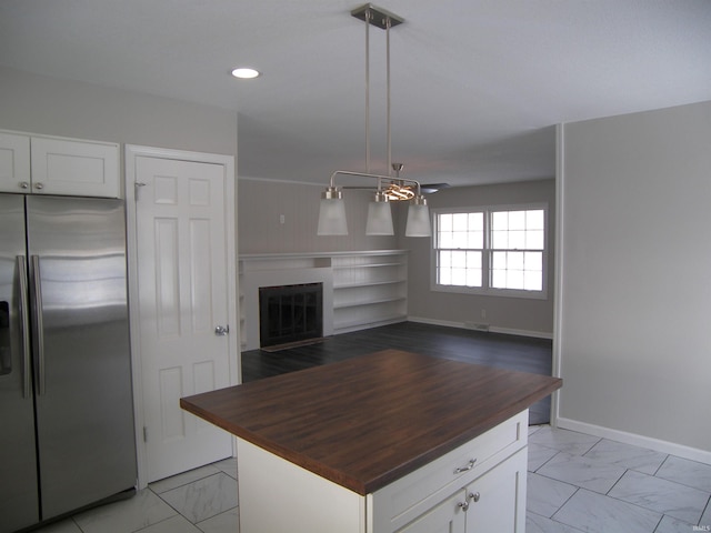 kitchen featuring butcher block countertops, decorative light fixtures, white cabinets, and stainless steel fridge with ice dispenser