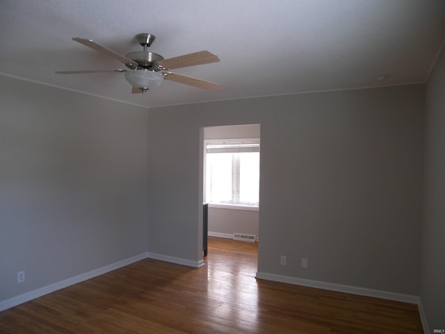 empty room with ceiling fan and dark hardwood / wood-style flooring