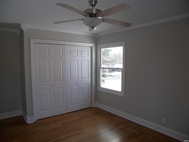 unfurnished bedroom featuring ceiling fan, a closet, crown molding, and dark hardwood / wood-style floors