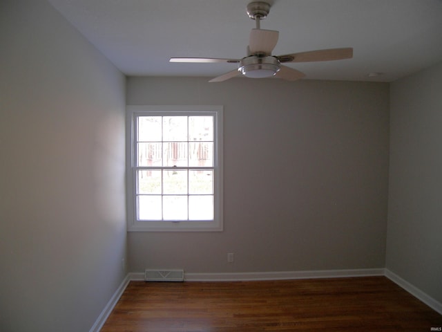 empty room with dark hardwood / wood-style flooring and ceiling fan