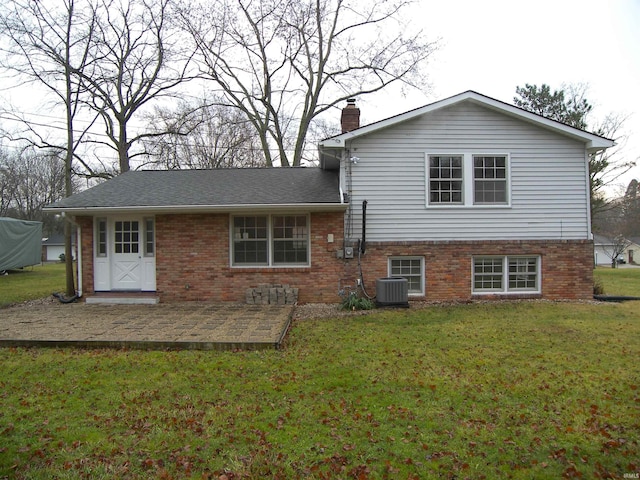 rear view of house with a lawn and central AC unit