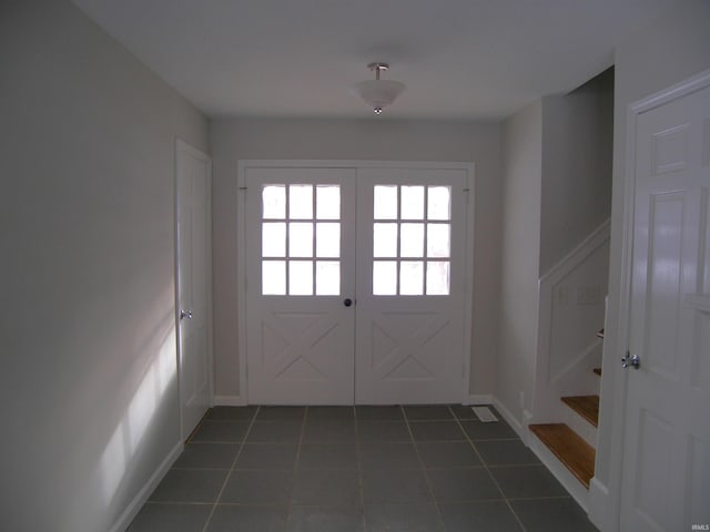 doorway to outside with french doors and dark tile patterned flooring