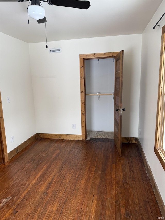 unfurnished bedroom featuring dark hardwood / wood-style flooring, a closet, and ceiling fan